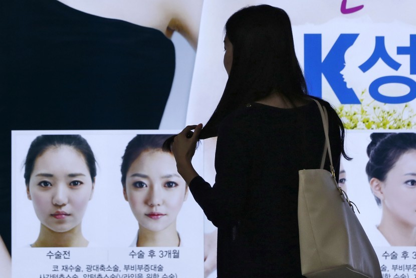 Seorang wanita sedang memperhatikan iklan operasi plastik di Seoul, Korsel. Kecantikan dan paras paripurna adalah hal penting bagi kaum muda Korea termasuk di Jakarta..