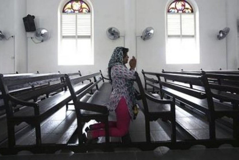 Seorang wanita tengah berdoa di Gereja Our Lady of Lourdes di Klang, luar Kuala Lumpur