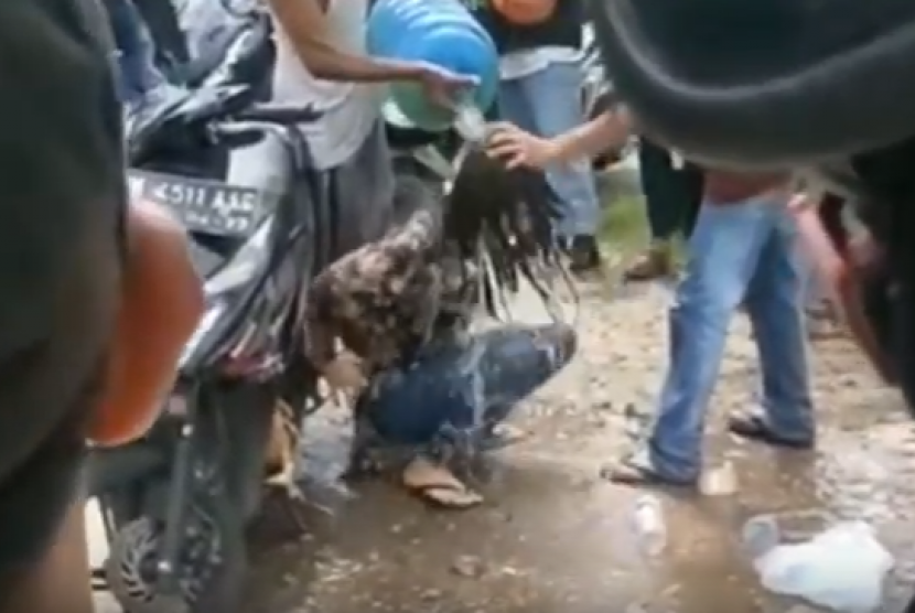 Seorang wanita terekam sedang geleng-geleng kepala di tepi jalan di Pekanbaru, Kamis (2/1). Polisi menyebut pelaku terpengaruh obat-obatan terlarang.