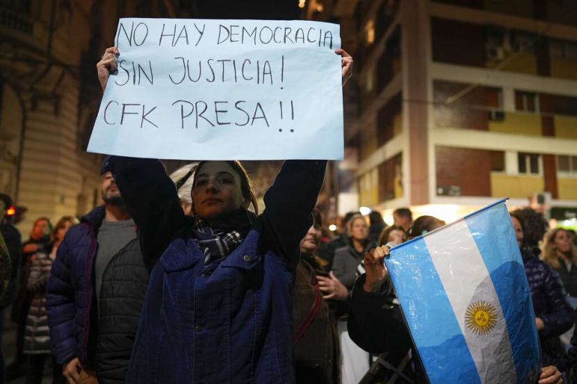 Seorang wanita yang menentang Wakil Presiden Argentina Cristina Fernandez memegang papan bertuliskan dalam bahasa Spanyol 