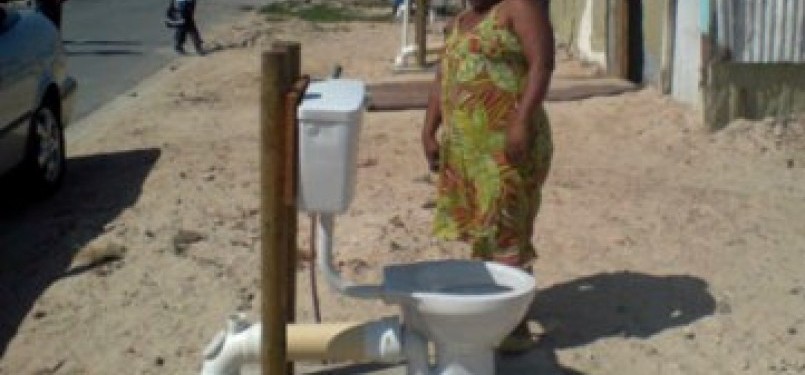 Seorang warga Afrika Selatan mengamati toilet terbuka di lingkungannya