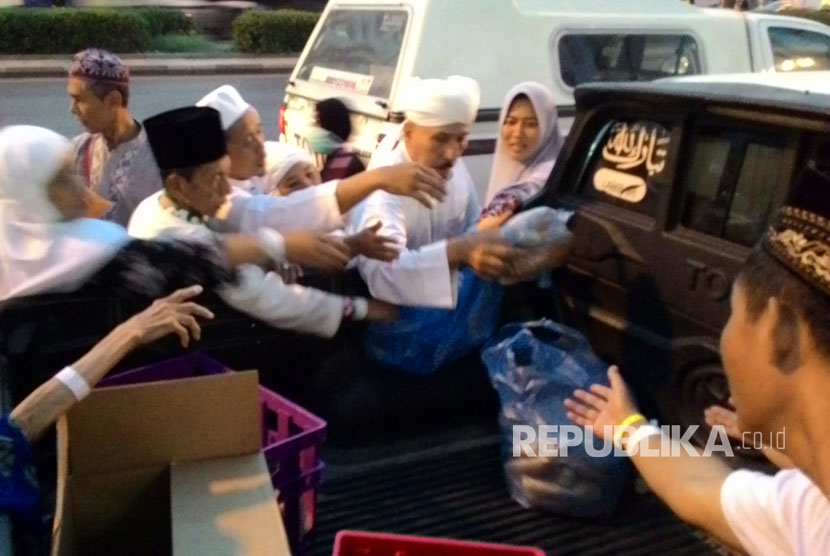  Seorang warga Arab Saudi membagi-bagikan roti dan kari kambing di depan hotel yang dihuni jamaah haji Indonesia usai shalat subuh, Senin (28/8). Pembagian itu disambut antusiasme jamaah. Mereka langsung menyerbu makanan yang dibawa dengan mobil pikap. 