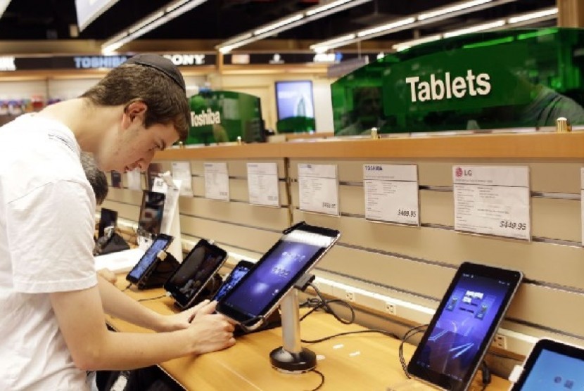 Seorang warga AS sedang mencoba tablet di sebuah toko gadget di New York 