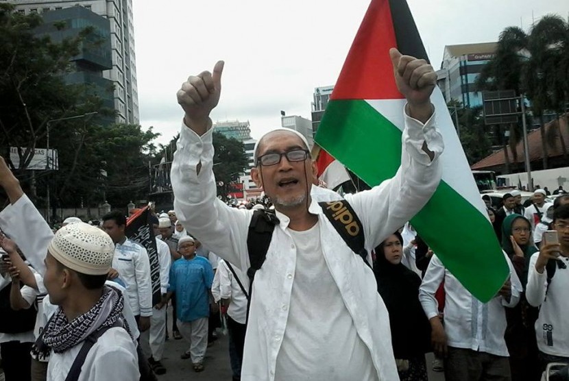 Seorang warga asal Bandung Otje Ardawilaga mengacungkan jempol di tengah acara aksi Bela Palestina di Lapangan Monas, Jakarta, Ahad (17/12).