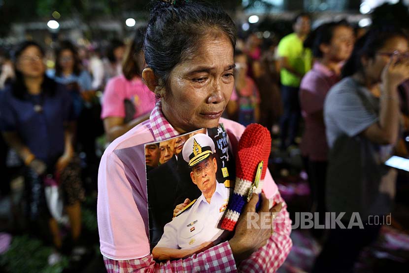 Seorang warga Bangkok membawa foto raja di depan rumah sakit tempat Raja Bhumibol Adulyadej di Bangkok, Thailand, Kamis (13/10)