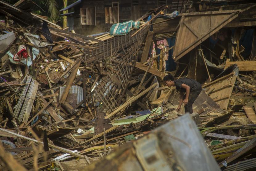 Seorang warga berada di puing-puing rumah akibat banjir bandang di Desa Waki, Kecamatan Batu Benawa,Kabupaten Hulu Sungai Tengah, Kalimantan Selatan.