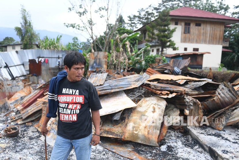 Seorang warga berada di puing rumahnya yang terbakar di kawasan Hom-hom, Kota Wamena, Kabupaten Jayawijaya, Papua, Sabtu (12/10/2019). 