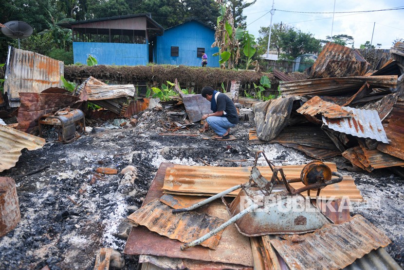 Seorang warga berada di puing rumahnya yang terbakar di kawasan Hom-hom, Kota Wamena, Kabupaten Jayawijaya, Papua, Sabtu (12/10/2019). Wakil Menteri PUPR John Wempi Wetipo(JWW) mengatakan hingga kini baru 10 rumah toko (ruko) yang dibangun pascakerusuhan Wamena. 