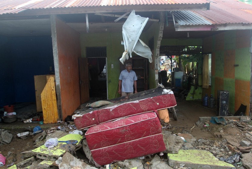 Seorang warga berada di rumahnya yang rusak akibat luapan air banjir kanal bandar bakali di kelurahan Alai Parak Kopi, Padang, Sumatera Barat, Sabtu (3/11/2018). 