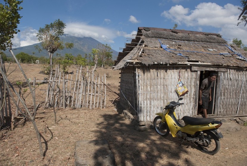 Seorang warga beraktivitas di rumahnya yang berjarak sekitar 10 kilometer dari Gunung Agung yang berstatus awas di Desa Datah, Karangasem, Bali, Selasa (26/9). 