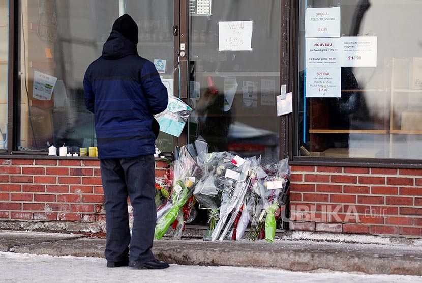 Seorang warga berdiri di toko kelontong milik Azzeddine Soufiane salah satu korban penembakan di Masjid di Pusat Kebudayaan Islam Quebec, Quebec City, Kanada.