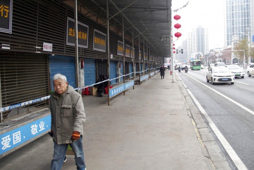 Seorang warga berjalan di pasar hidangan laut Huanan di Wuhan, China. Uni Eropa (EU) tengah mendorong kesepakatan global untuk mencegah pandemi baru. Menurut seorang pejabat, kesepakatan ini termasuk melarang pasar hewan liar