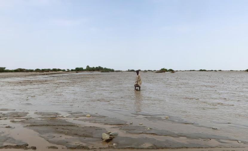 Seorang warga berjalan melewati air banjir, di Port Sudan, Sudan, 26 Agustus 2024.