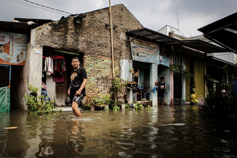 Seorang warga berjalan melintasi banjir di Margasari, Karawaci, Kota Tangerang, Banten, Rabu (11/5/2022). Hujan deras yang mengguyur sejak Selasa (10/5) malam mengakibatkan kawasan tersebut terendam banjir hingga ketinggian 70 cm.