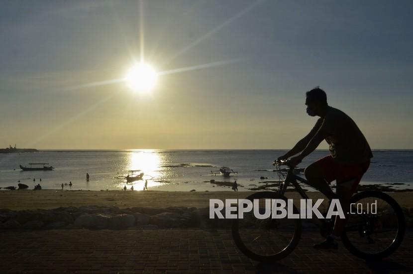 Wisatawan bersepeda di Pantai Jerman, Kabupaten Badung, Bali, Sabtu (19/9). Pariwisata Bali terpukul pandemi Covid-19 hingga menimbulkan kerugian Rp 9,7 triliun per bulan.