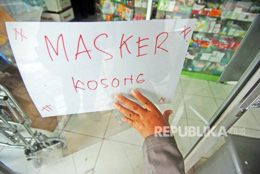 Seorang warga bersiap masuk ke dalam apotik yang memasang tulisan masker kosong di Tegal, Jawa Tengah, Kamis (5/3/2020). 