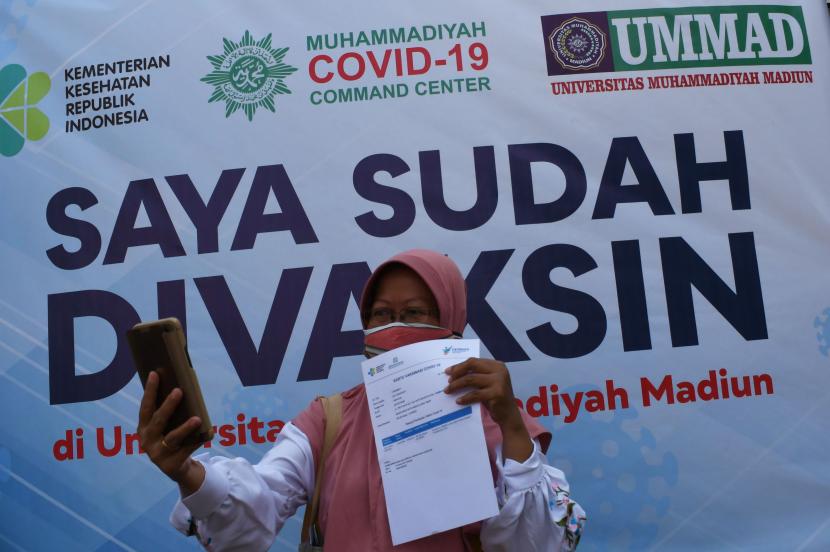 Seorang warga berswafoto seusai menerima suntikan vaksin saat vaksinasi massal COVID-19 lintas agama di halaman kampus Universitas Muhammadiyah Madiun, Jawa Timur, Sabtu (21/8/2021). Berdasarkan data Kemenkes, hingga Jumat (20/8) capaian vaksinasi COVID-19 di Jawa Timur dosis pertama sebanyak 8.621.191 orang atau 27,09 persen dari sasaran vaksinasi 31.826.206 orang dan dosis kedua sebanyak 4.739.015 atau 14,89 persen dari sasaran.
