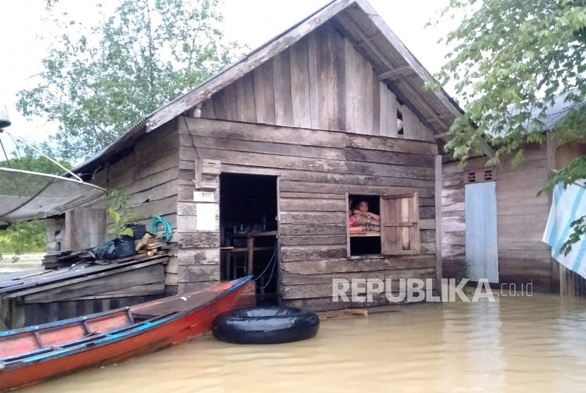 Banjir Kabupaten Sintang, Dua Orang Meninggal Dunia. Foto: Seorang warga di Kalimantan tetap bertahan di rumahnya saat banjir (ilustrasi).