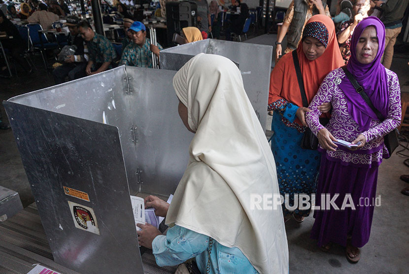 Seorang warga memasukkan  surat suara ke dalam kotak suara, saat simulasi pencoblosan Pilkada Serentak (Ilustrasi) 