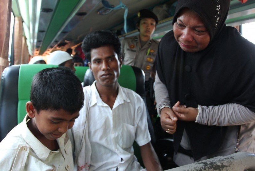 Seorang warga (kanan) menangis melepas pemindahan Husain (kiri) salah seorang anak imigran etnis Rohingya, Myanmar pada proses pemindahan dari penampungan sementara, Pangkalan Susu, Langkat, Sumatera Utara, Senin (18/5).