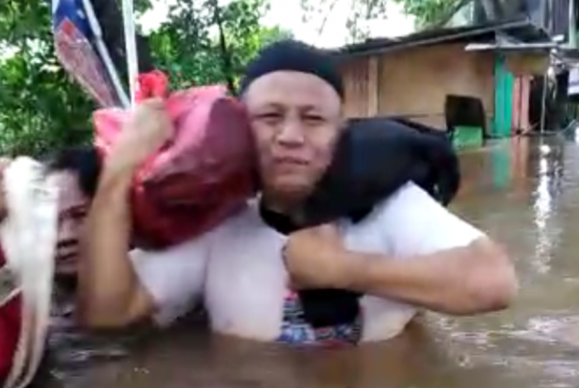 Seorang warga Kartika Baru, Ciledug, berada di tengah banjir.