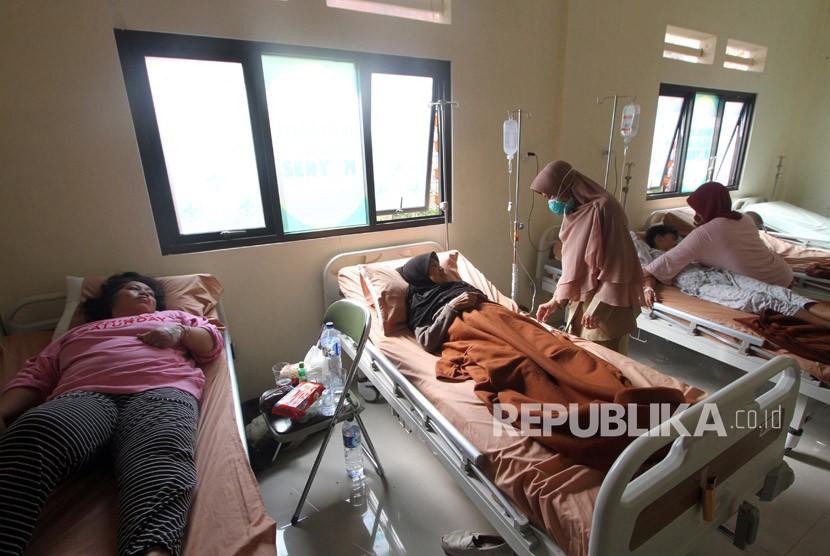 Seorang warga korban keracunan makanan setelah mengkonsumsi tutut atau keong sawah mendapat perawatan medis di Puskesmas Bogor Utara, Bogor, Jawa Barat, Senin (28/5). 