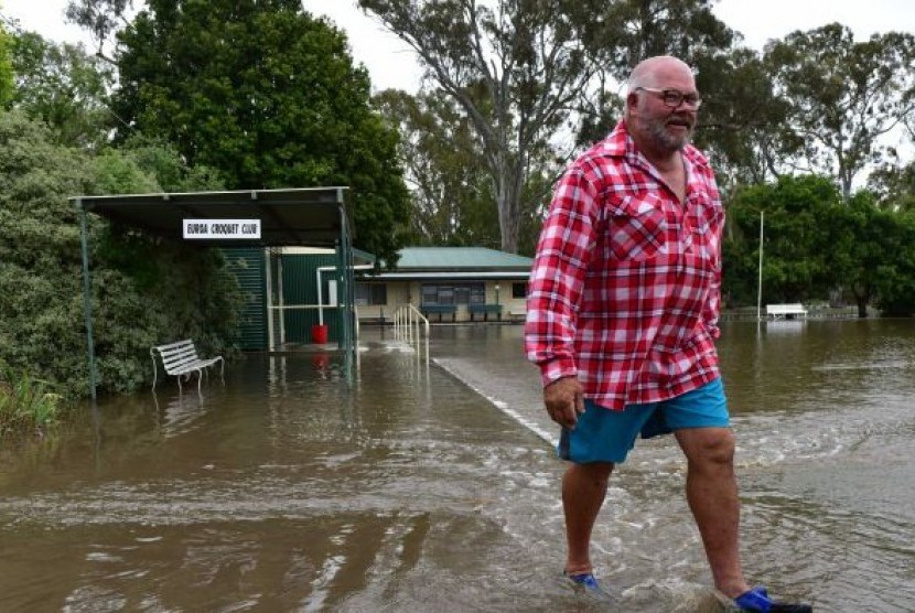 Seorang warga lokal melewati genangan air di kawasan Euroa, Victoria, Australia, Sabtu (2/12).