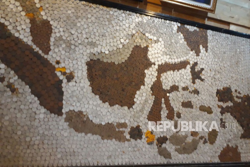 Seorang warga Malang membuat peta Indonesia dalam hiasan koin kuno. 