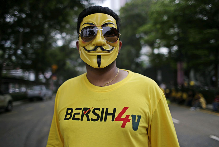 Seorang warga Malaysia mengenakan topeng saat turun ke jalan kota Kuala Lumpur, mendesak PM Najib Razak mengundurkan diri dari jabatannya.  (EPA/Fazry Ismail)