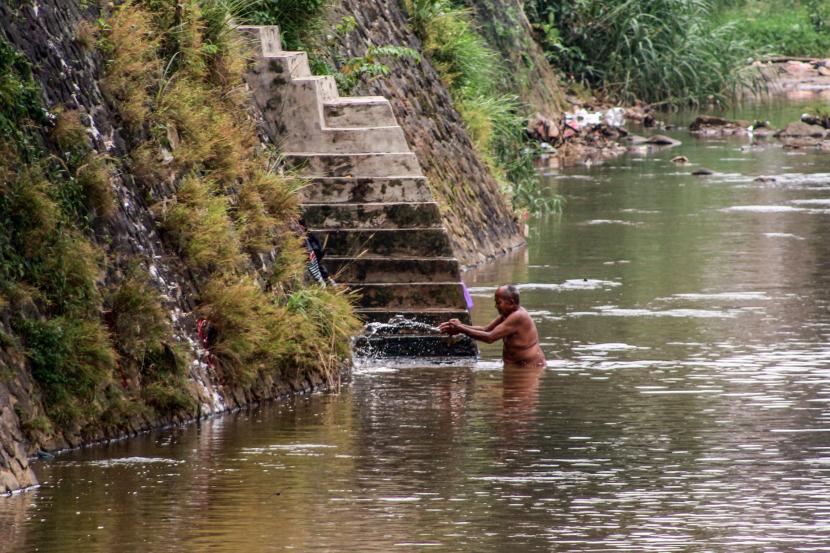 Seorang warga mandi di aliran Sungai Cisadane, Pancasan, Kota Bogor, Jawa Barat, Selasa (30/11/2021). Badan Perencanaan Pembangunan Nasional (Bappenas) menargetkan angka kemiskinan bisa turun 0,5 persen di tahun 2022 dari persentase kemiskinan saat ini yang mencapai 10,14 persen.