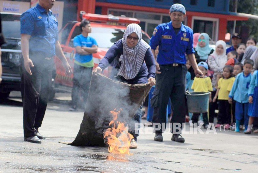 Seorang warga melakukan simulasi penanganan kebakaran di halaman kantor Pemadam Kebakaran, Jl Sukabumi, Kota Bandung, Rabu (30/3). Simulasi digelar sebagai tindakan pertama pencegahan kebakaran dan meningkatkan kewaspadaan akan bencana kebakaran.