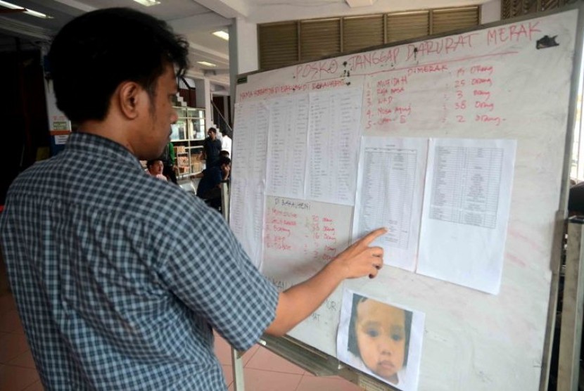 Seorang warga melihat data nama-nama korban dalam kecelakaan kapal Bahuga Jaya dengan Kapal Kargo di pelabuhan Merak, Banten, Rabu (26/9)