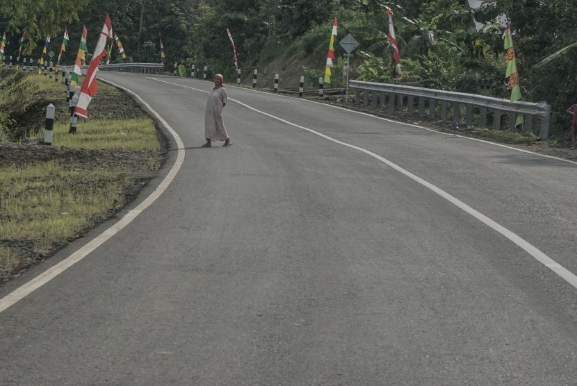Seorang warga melintasi jalur lingkar Sumpiuh di Simpang Tambak, Banyumas, Jawa Tengah, Rabu (22/6). 