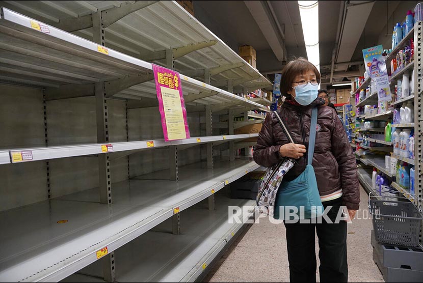 Seorang warga melintasi rak tisu yang kosong di sebuah supermarket di Hong Kong, Kamis, (6/2). Warga memborong berbagai kebutuhan dasar di toko-toko seiring merebaknya wabah virus corona dari China daratan.