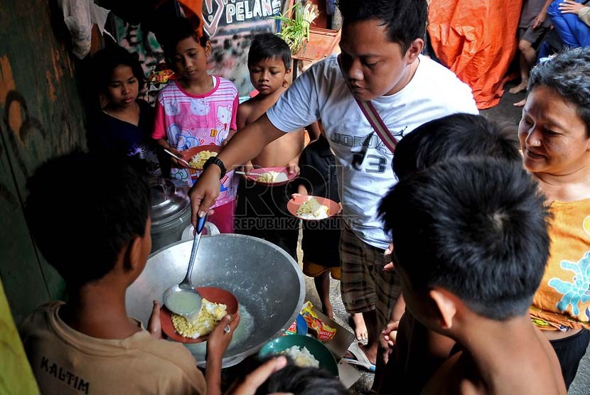  Seorang warga memasak mie instan untuk anak-anak korban banjir di kawasan Kampung Pulo, Jakarta timur, Rabu (15/1).   (Republika/Prayogi)