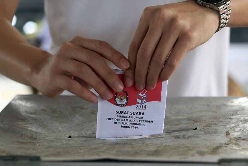  Seorang warga memasukkan kertas suara pilpres ke dalam kotak suara di Bali, Rabu (9/7).