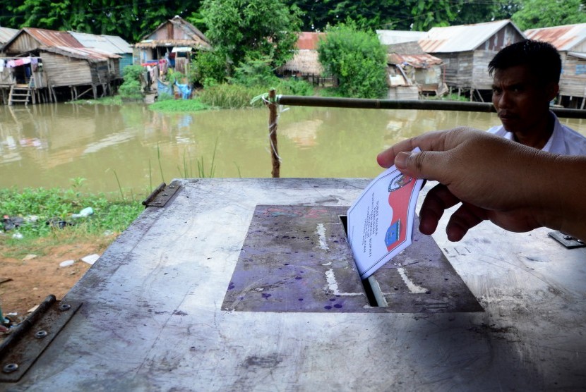 Seorang warga memasukkan surat suara ke dalam kotak suara saat menggunakan hak pilih pada Pilkada Kabupaten Ogan Ilir di TPS 2 di Desa Ibul Besar 2 Kecamatan Pemulutan, Sumatera Selatan, Rabu (9/12).