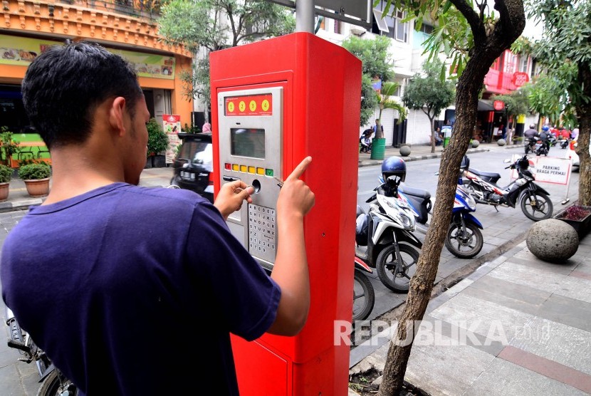  Seorang warga membayar parkir di tempat mesin smartparking, Jalan Braga, Kota Bandung, Kamis (5/10). 