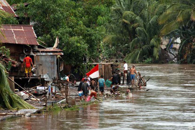 Seorang warga membersihkan lumpur rumahnya setelah terendam banjir di Manado, Sulawesi Utara, Kamis (16/1). Badan Nasional Penanggulangan Bencana (BNPB) Sulut menyatakan banjir telah menelan 15 korban, 6 di Manado , Tomohon 5 dan Minahasa 4 korban jiwa. 