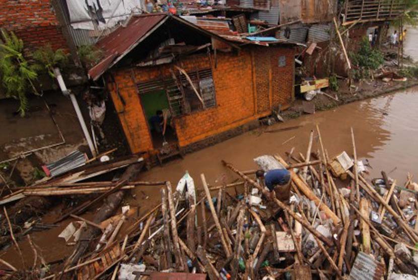 Seorang warga membersihkan lumpur rumahnya setelah terendam banjir di Manado, Sulawesi Utara, Kamis (16/1). Badan Nasional Penanggulangan Bencana (BNPB) Sulut menyatakan banjir telah menelan 15 korban, 6 di Manado , Tomohon 5 dan Minahasa 4 korban jiwa. 