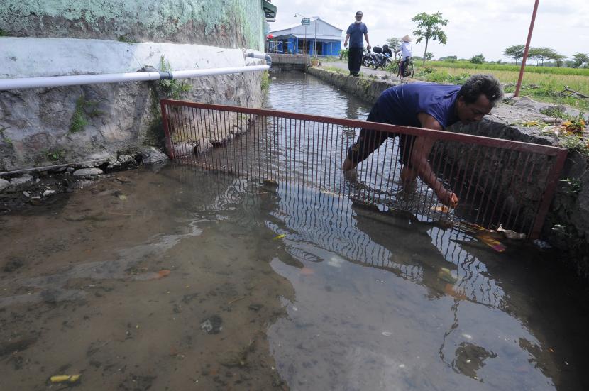Seorang warga membersihkan sampah di saluran irigasi (ilustrasi). Bank Nagari menyatakan kesiapannya membiayai percepatan pembangunan infrastruktur dasar pertanian seperti irigasi di Kabupaten Pesisir Selatan, Sumatra Barat.