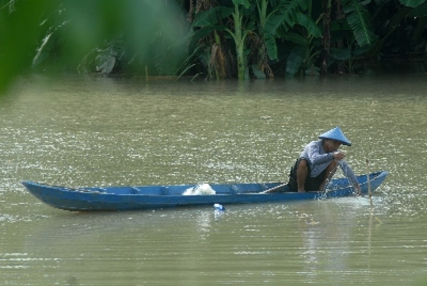 Seorang warga memeriksa jaring ikan miliknya yang ditebar di areal persawahan yang terendam air luapan dari Bengawan Solo di Desa Pelangwot, Lamongan, Jawa Timur, Senin (7/1)