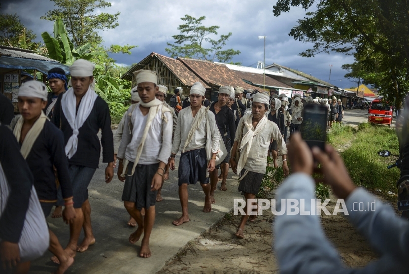 Seorang warga memotret ribuan warga Suku Baduy yang tengah berjalan kaki menuju Pendopo Kabupaten Rangkasbitung dalam rangka Seba Baduy di Banten, Jumat (28/4).