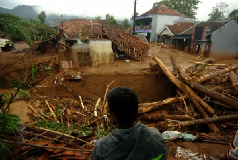 Seorang warga memperhatikan pemukiman yang terkena banjir material longsor di Desa Pasirpanjang, Salem, Brebes, Jawa Tengah, Jumat (23/2). Puluhan rumah hancur dan penuh lumpur akibat terkena material longsor bukit Gunung Lio. 