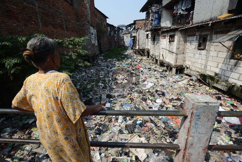  Seorang warga memperhatikan sungai yang dipenuhi sampah di Muara Baru, Jakarta utara, Selasa (19/5). 