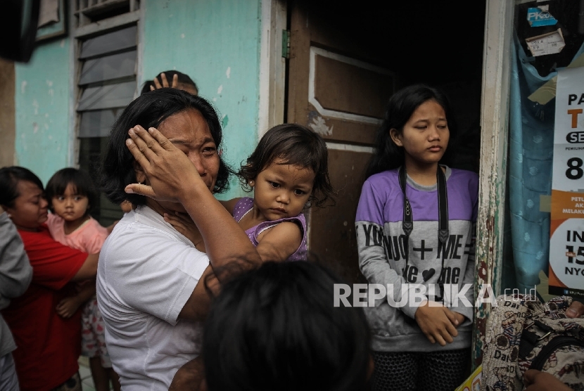  Seorang warga menangis saat penggusuran di permukiman proyek normalisasi Sungai Ciliwung, Bukit Duri, Jakarta, Rabu (28/9)