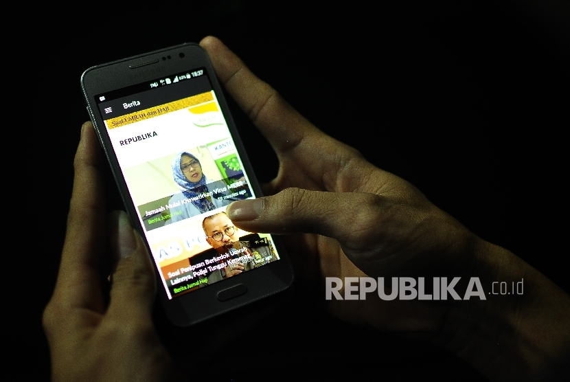 Seorang warga mengakses aplikasi Ihram di Jalan Pejaten Raya, Jakarta, Senin (14/8).