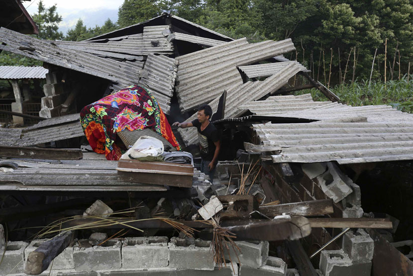 Seorang warga mengamankan kasur dari rumahnya yang hancur akibat gempa skala 6,1 SR yang menguncang Yingjiang, Provinsi Yunan, Cina, Jumat (30/5). 