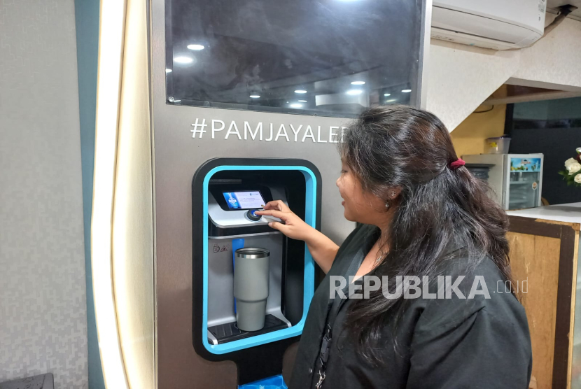 Seorang warga mengambil air dari water purifier yang berada di Balai Kota Jakarta, Senin (17/2/2025). 