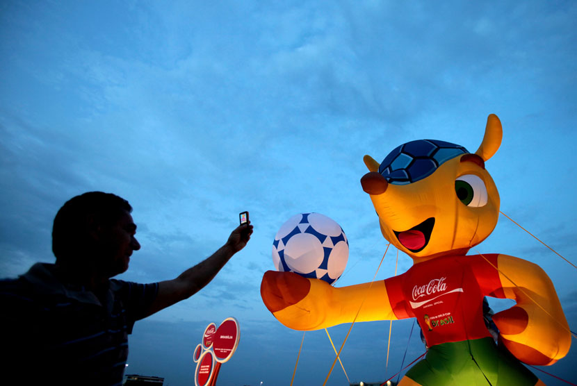 Seorang warga mengambil foto Fuleco, maskot Piala Dunia 2014, di salah satu sudut kota Brasilia. 